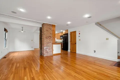 a view of an empty room with wooden floor
