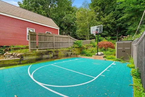 a view of a tennis ground with large trees