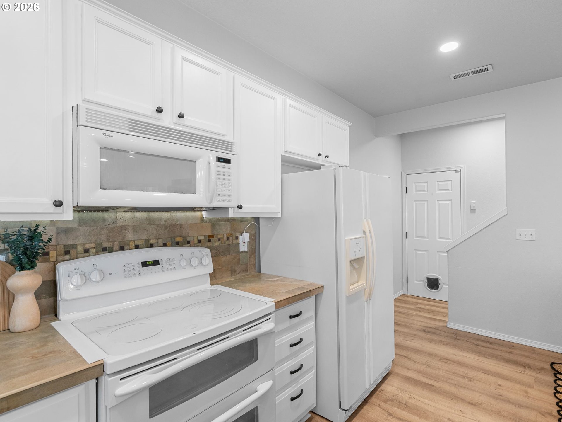 6225 Southwest 182nd Terrace Beaverton, OR 97007 - Photo 13 of 36 a kitchen with white cabinets and refrigerator