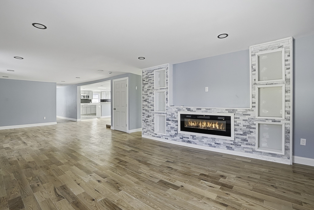 140 Spring Street Athol, MA 01331 - Photo 8 of 42 a view of a living room a fireplace with wooden floor and a rug