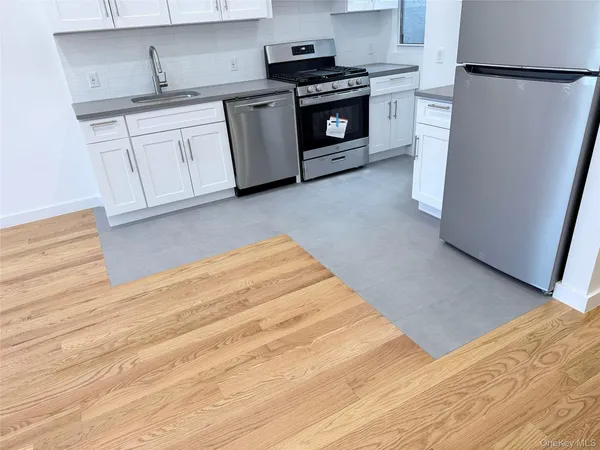 a kitchen with stainless steel appliances white cabinets and a refrigerator