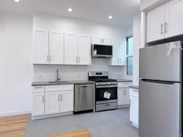 a kitchen with stainless steel appliances white cabinets and a refrigerator