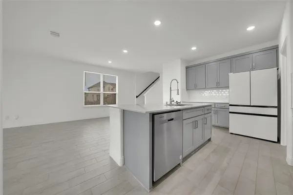 a kitchen with appliances a sink and a refrigerator