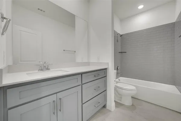 a bathroom with a granite countertop toilet a sink and a bathtub