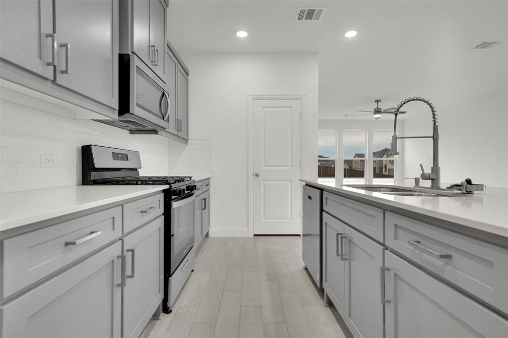 2901 Isla Terrace Princeton, TX 75407 - Photo 10 of 33 a kitchen with stainless steel appliances granite countertop a sink and cabinets