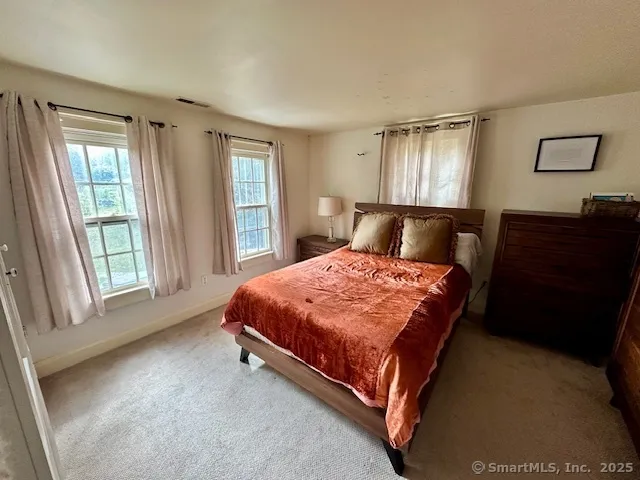 a bed sitting in a bedroom next to a window