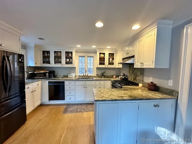 a kitchen with a refrigerator sink and cabinets