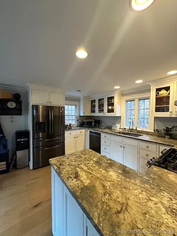 a kitchen with stainless steel appliances granite countertop a refrigerator and a stove top oven
