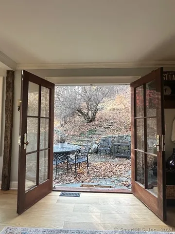 a view of a livingroom with wooden floor and a balcony