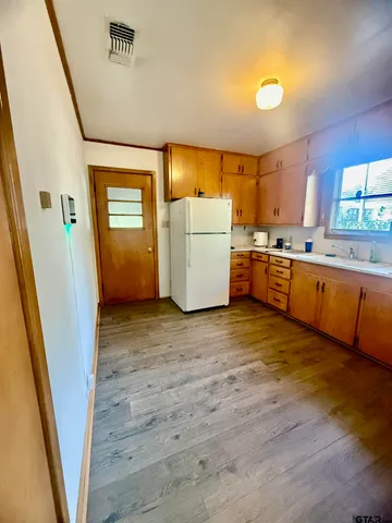 a large kitchen with wooden floors and a sink