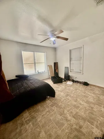 an empty room with windows and fan