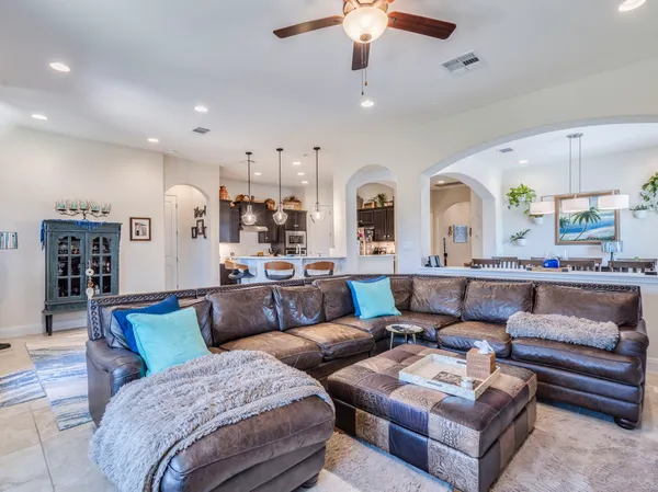 a living room with furniture ceiling fan and a rug
