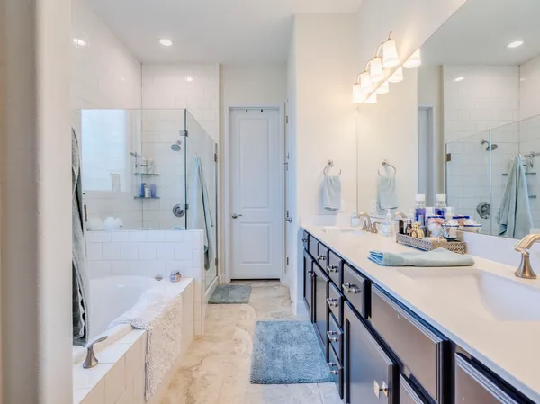 a bathroom with a tub sink shower and mirror