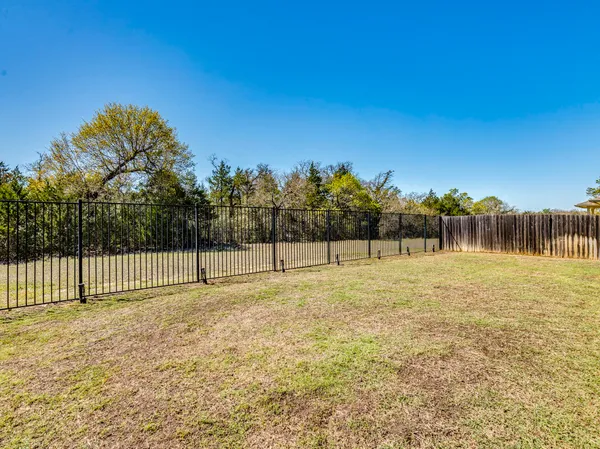 a view of a yard with wooden fence