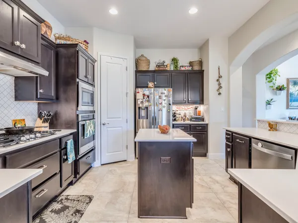 a kitchen with stainless steel appliances kitchen island granite countertop a refrigerator and a stove top oven