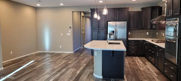 a kitchen with stainless steel appliances a refrigerator and a stove top oven