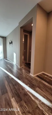 a view of a hallway with wooden floor and a living room