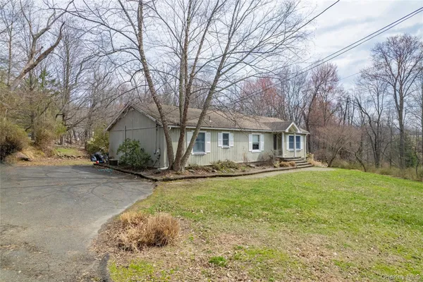a view of a house with backyard and trees