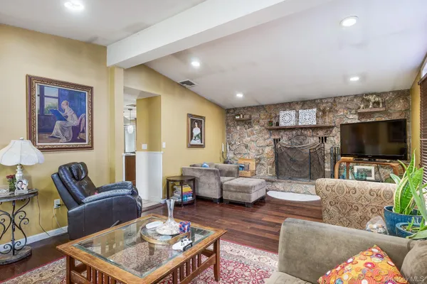 a living room with furniture a flat screen tv and a fireplace