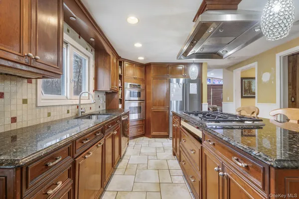 a large kitchen with granite countertop a sink and cabinets