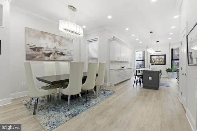 a view of a dining room with furniture a chandelier and wooden floor