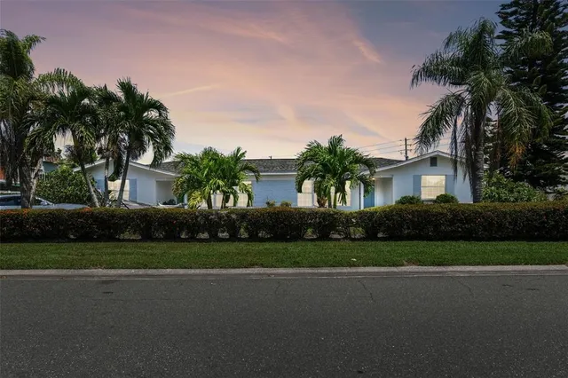 a front view of a house with a garden and trees