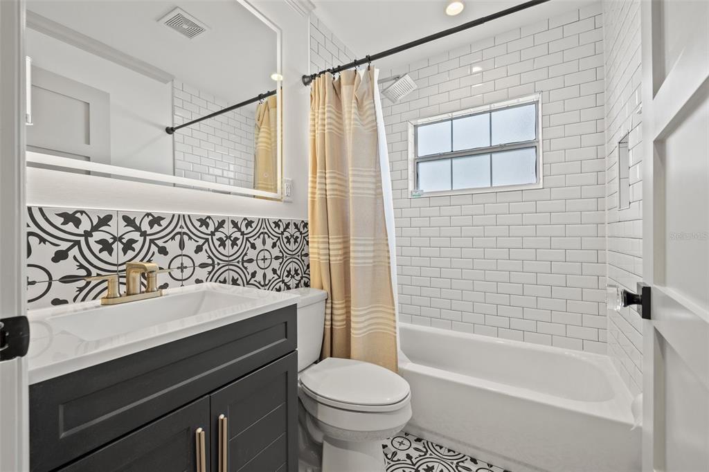 11225 2nd Street East, Unit A Treasure Island, FL 33706 - Photo 14 of 25 a bathroom with a sink a toilet and a bathtub