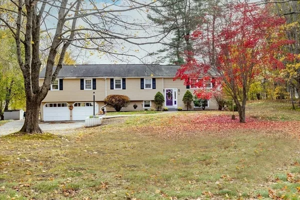 a front view of a house with a yard covered with snow