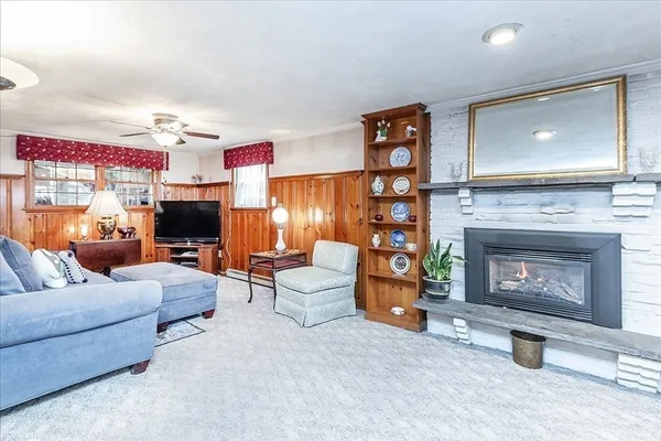 a living room with furniture a flat screen tv and a fireplace