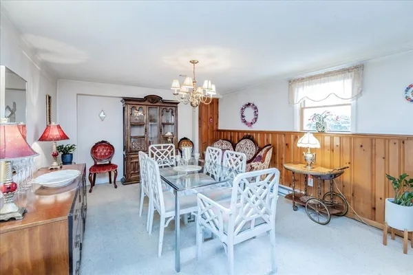 a dining room with furniture a chandelier and a rug