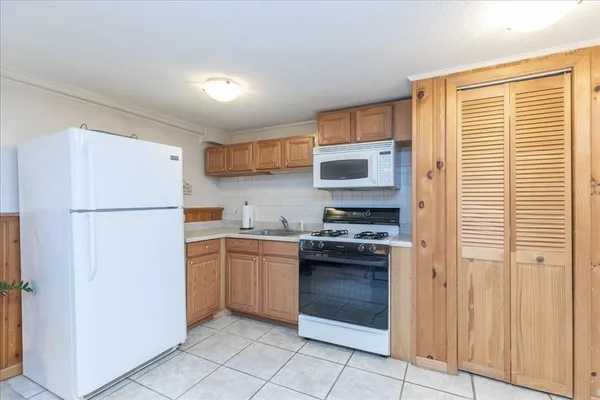 a kitchen with stainless steel appliances granite countertop a refrigerator sink and stove