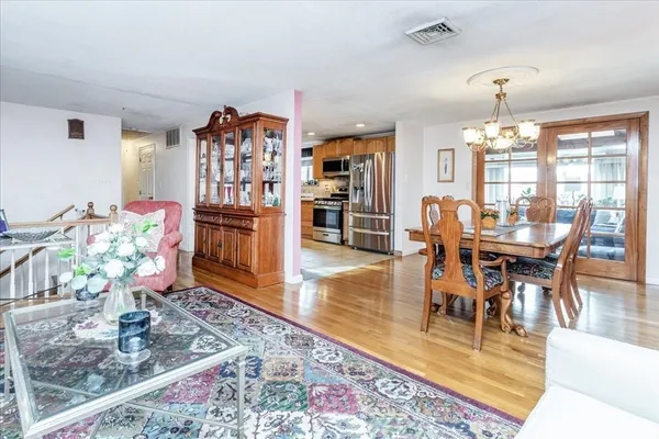 a dining room with furniture a rug and a chandelier