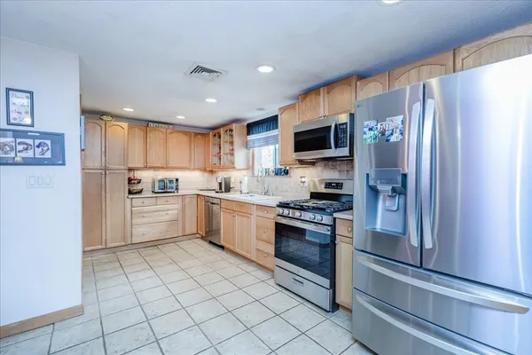 a kitchen with a refrigerator a sink and a stove top oven