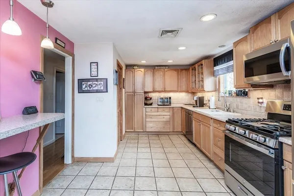 a kitchen with stainless steel appliances granite countertop a refrigerator and a stove top oven