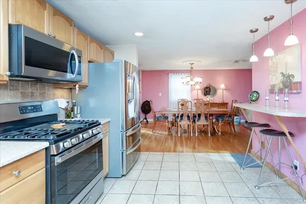 a kitchen with stainless steel appliances kitchen island granite countertop a stove a sink a microwave and dining table