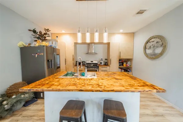 a kitchen with stainless steel appliances granite countertop a sink stove and refrigerator