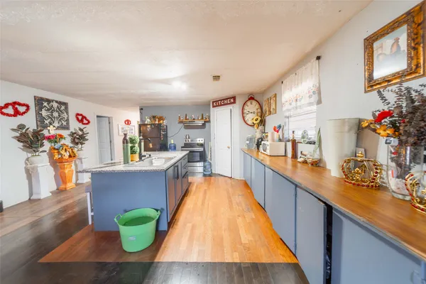 a kitchen with granite countertop a stove a sink and a refrigerator