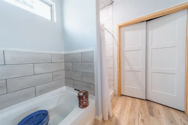 a bathroom with a tub sink and mirror