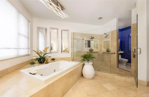a spacious bathroom with a granite countertop sink a large mirror and a bathtub