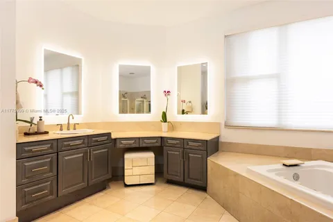 a large bathroom with a tub sink and mirror
