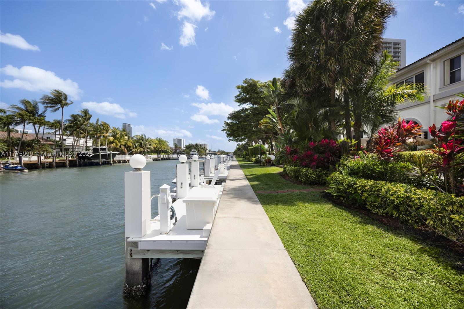 3707 Northeast 214th Street, Unit 14 Aventura, FL 33180 - Photo 34 of 47 a view of a lake with a bench under an umbrella