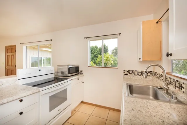 a view of a big room with windows and chandelier fan