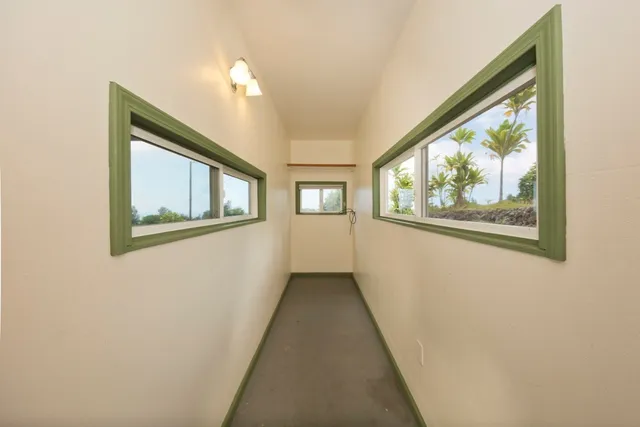 an empty room with a window and a ceiling fan