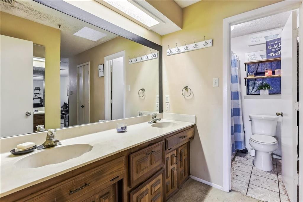8123 Hilltop Road Argyle, TX 76226 - Photo 20 of 34 a bathroom with a double vanity sink toilet and a mirror
