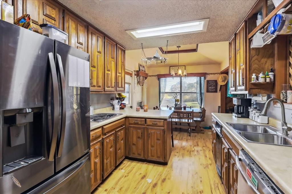8123 Hilltop Road Argyle, TX 76226 - Photo 28 of 34 a kitchen with stainless steel appliances a sink cabinets and wooden floor