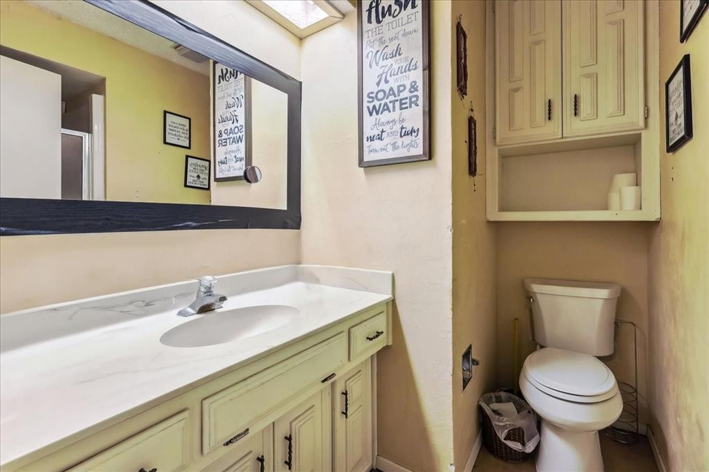8123 Hilltop Road Argyle, TX 76226 - Photo 31 of 34 a bathroom with a sink mirror vanity and toilet