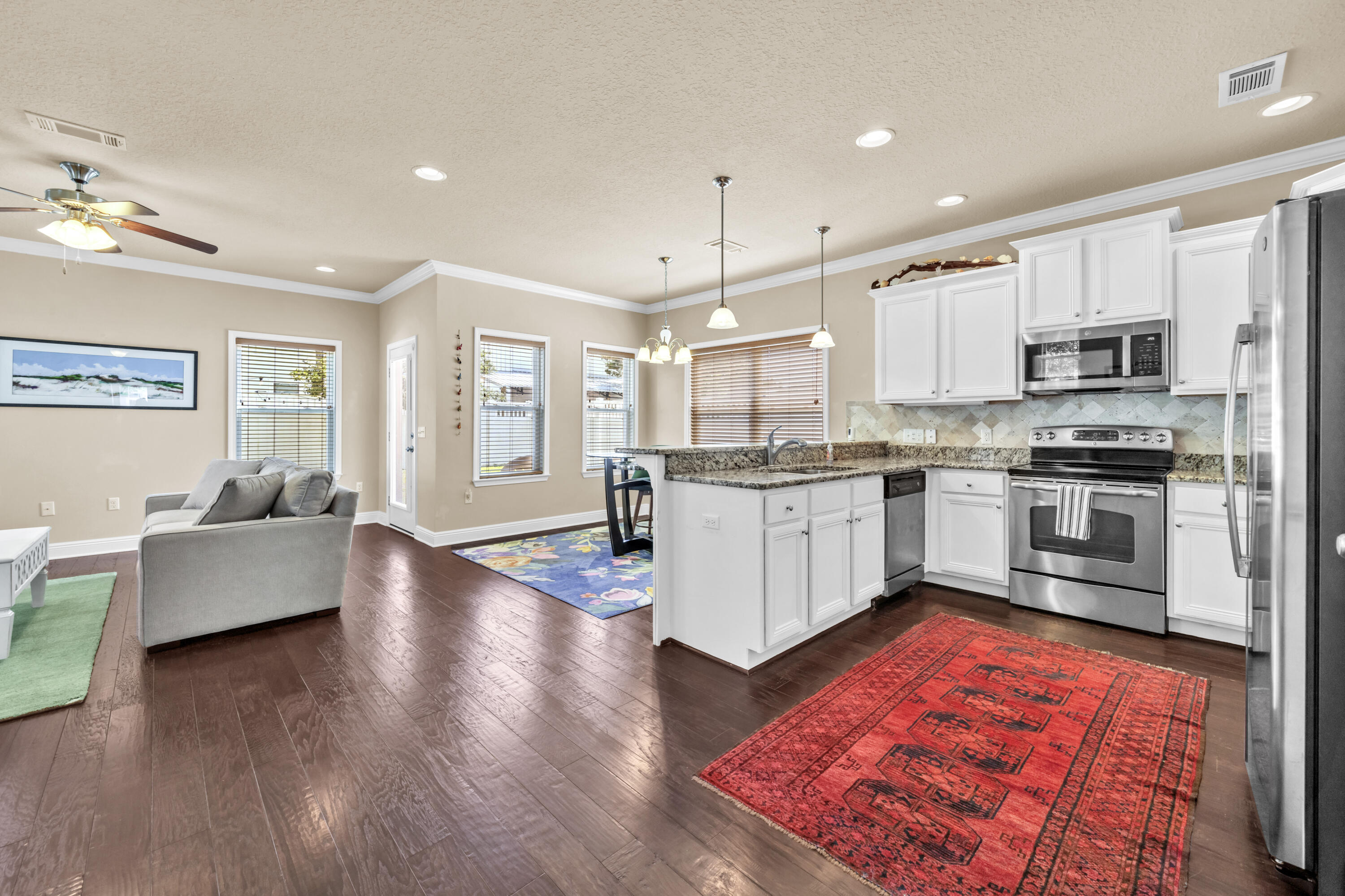 19 Topside Drive Inlet Beach, FL 32461 - Photo 3 of 28 a kitchen with stainless steel appliances granite countertop a refrigerator a stove top oven a sink dishwasher and white cabinets with wooden floor