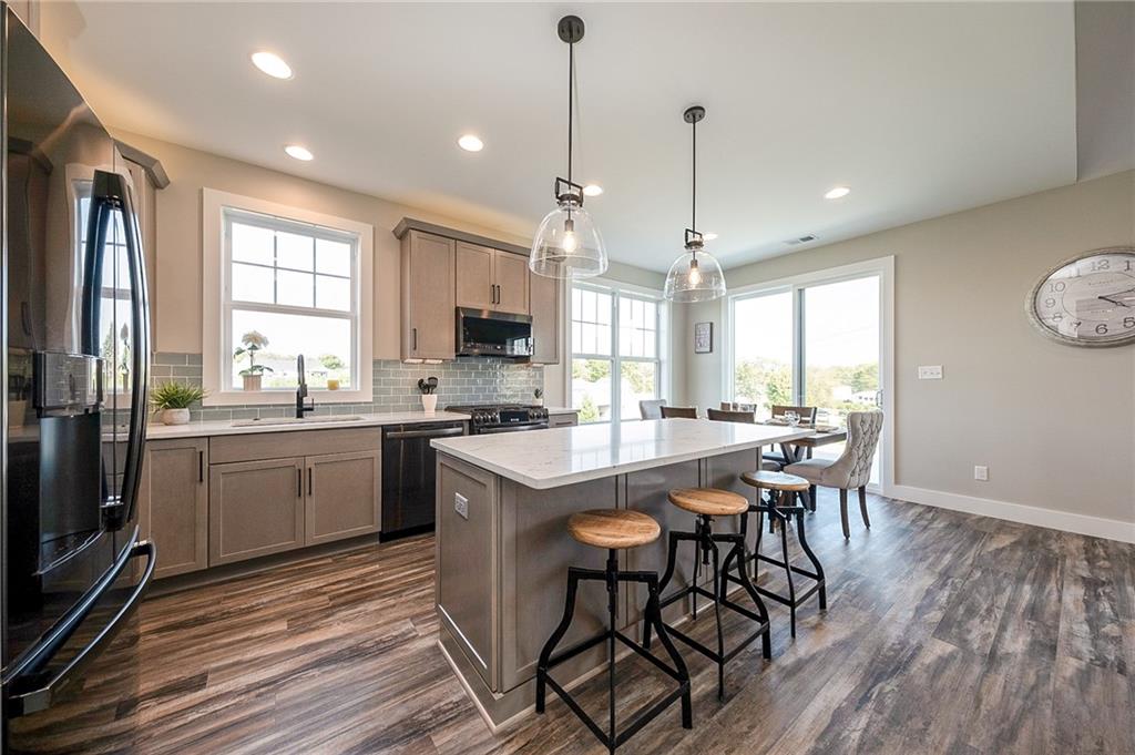 103 Ridge Line Drive Apollo, PA 15613 - Photo 20 of 39 a kitchen with stainless steel appliances granite countertop a kitchen island hardwood floor sink stove dining table and chairs