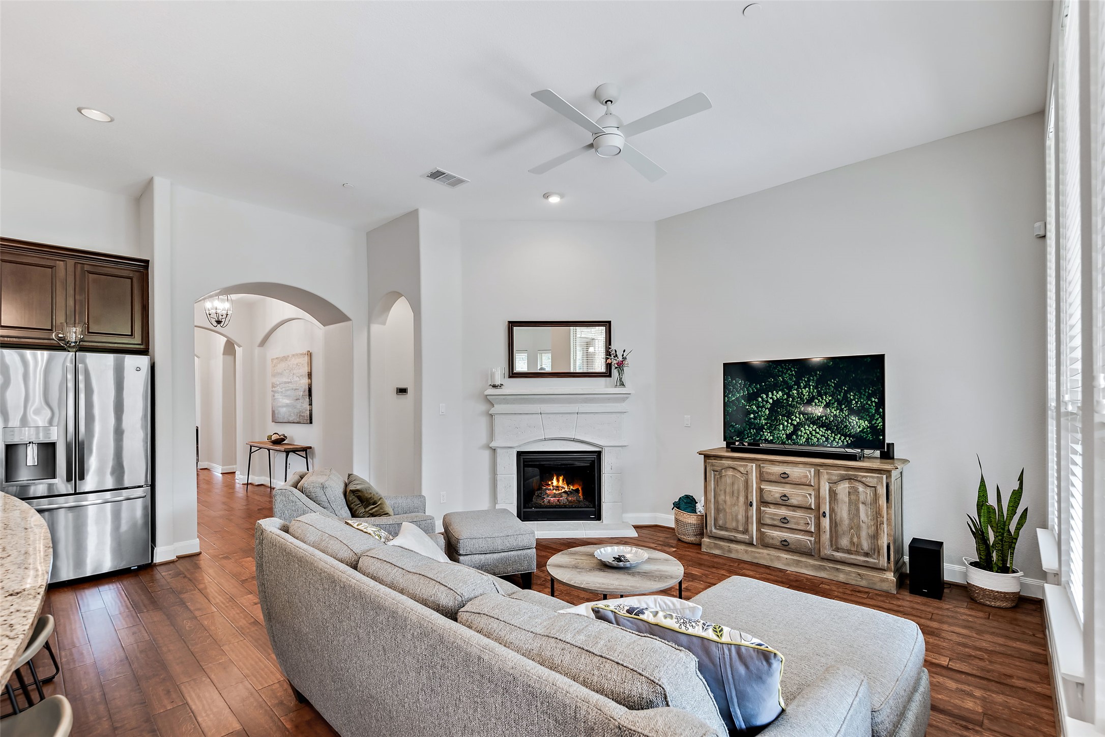 106 Maxwell Way Austin, TX 78738 - Photo 32 of 40 Living area with ceiling fan, wood floors, fireplace, arched walkways, and recessed lighting