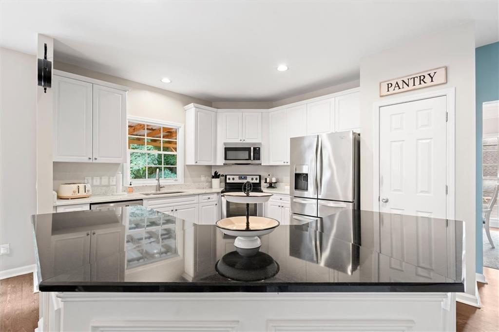 326 Senators Ridge Drive Dallas, GA 30132 - Photo 11 of 37 a kitchen with white cabinets and stainless steel appliances